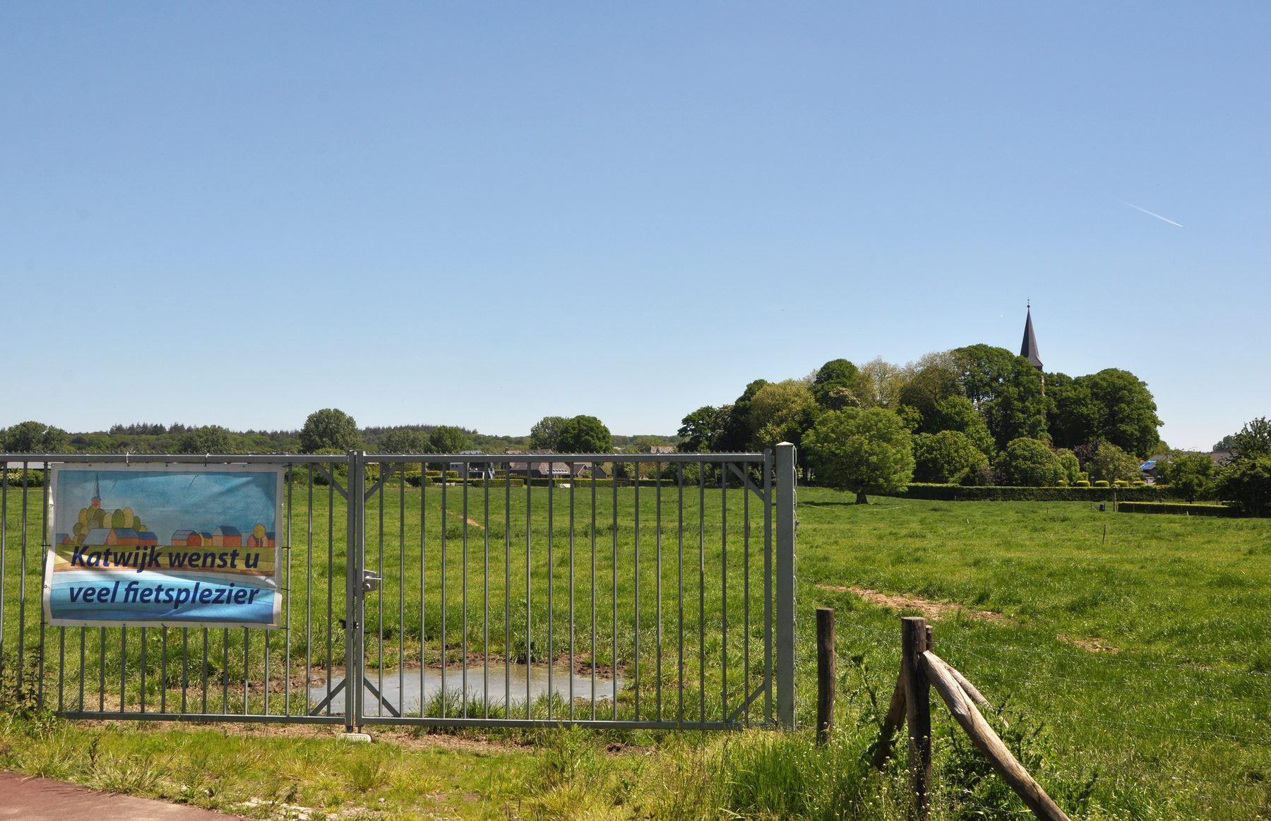 Fietsplezierbord met de kerktoren in het groene landschap van Katwijk