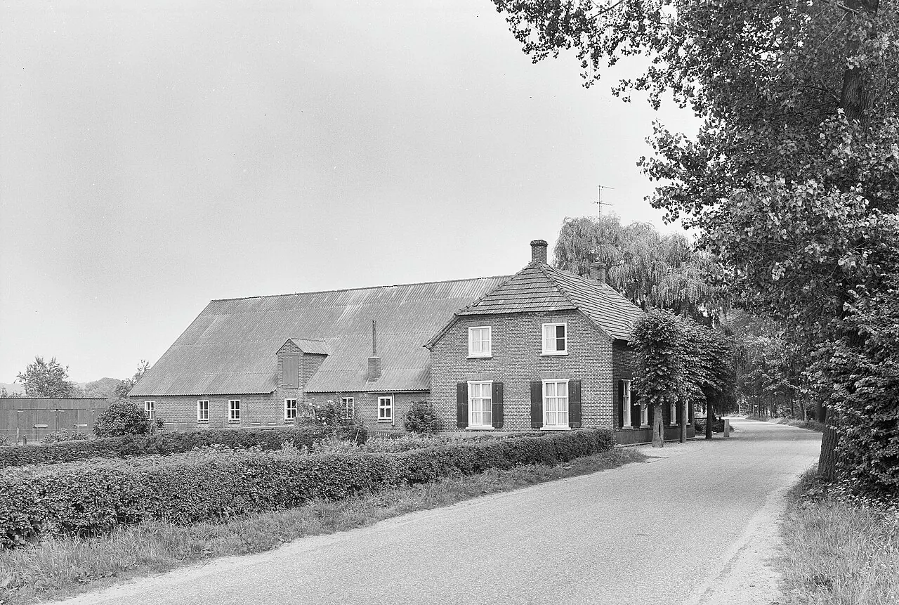 Historische zwart-witfoto van een lange boerderij tussen bomen in Katwijk NB